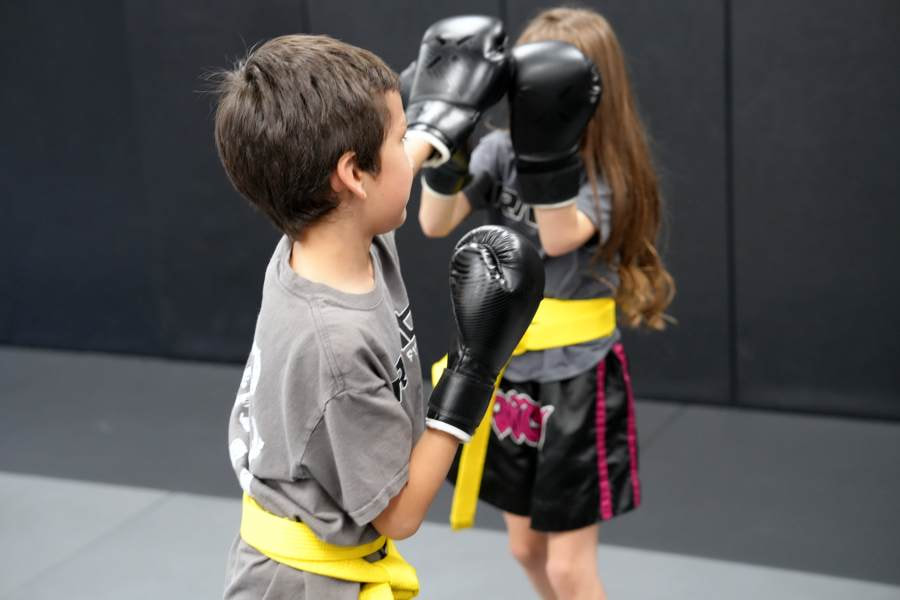 Youth Muay Thai class practicing their self defense skills and blocking punches