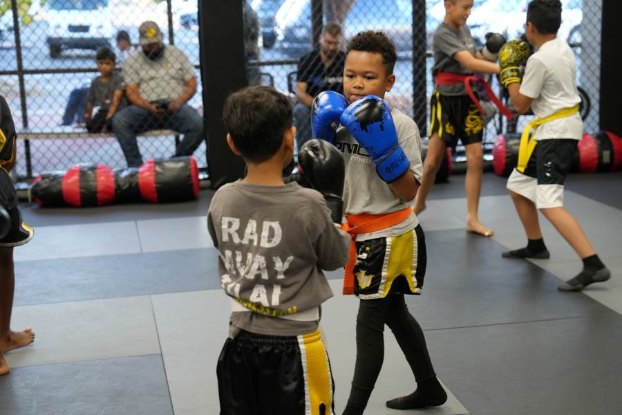 Students learning and practicing their techniques during Youth Muay Thai class